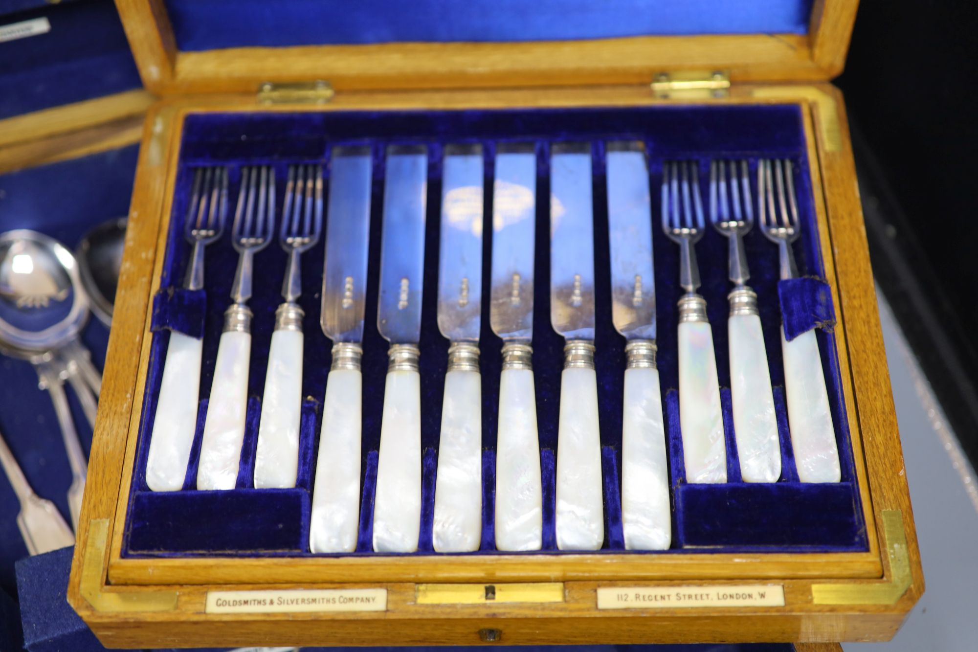 A cased set of silver dessert knives and forks and two other boxes